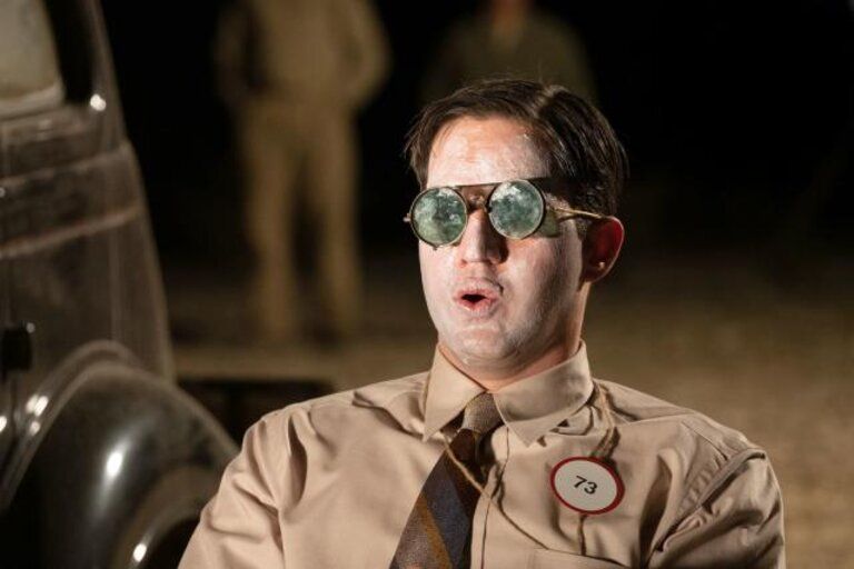 A shot from the movie Oppenheimer where Edward Teller observes an atomic bomb explosion wearing sunglasses with an astonished face