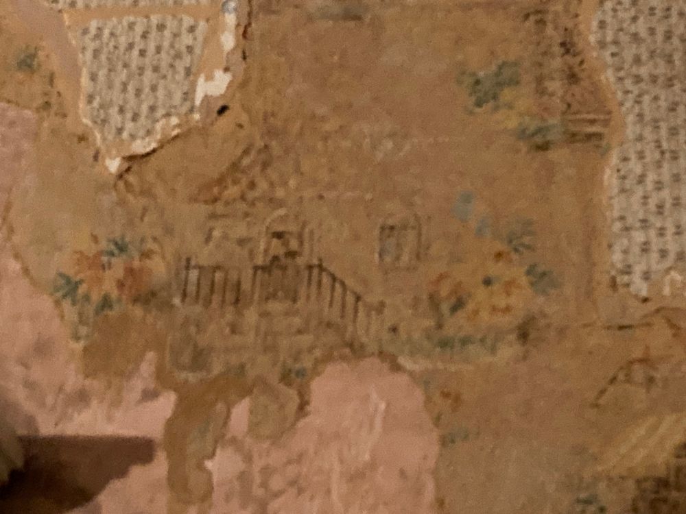 More of the village pattern, in less focus because I was zoomed in up near the ceiling. There are clusters of yellow flowers and a house with an iron-railed balcony.