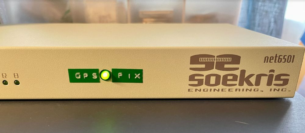 old Soekris net6501 network appliance, with green LED indicating "GPS fix" in embossed green labelling