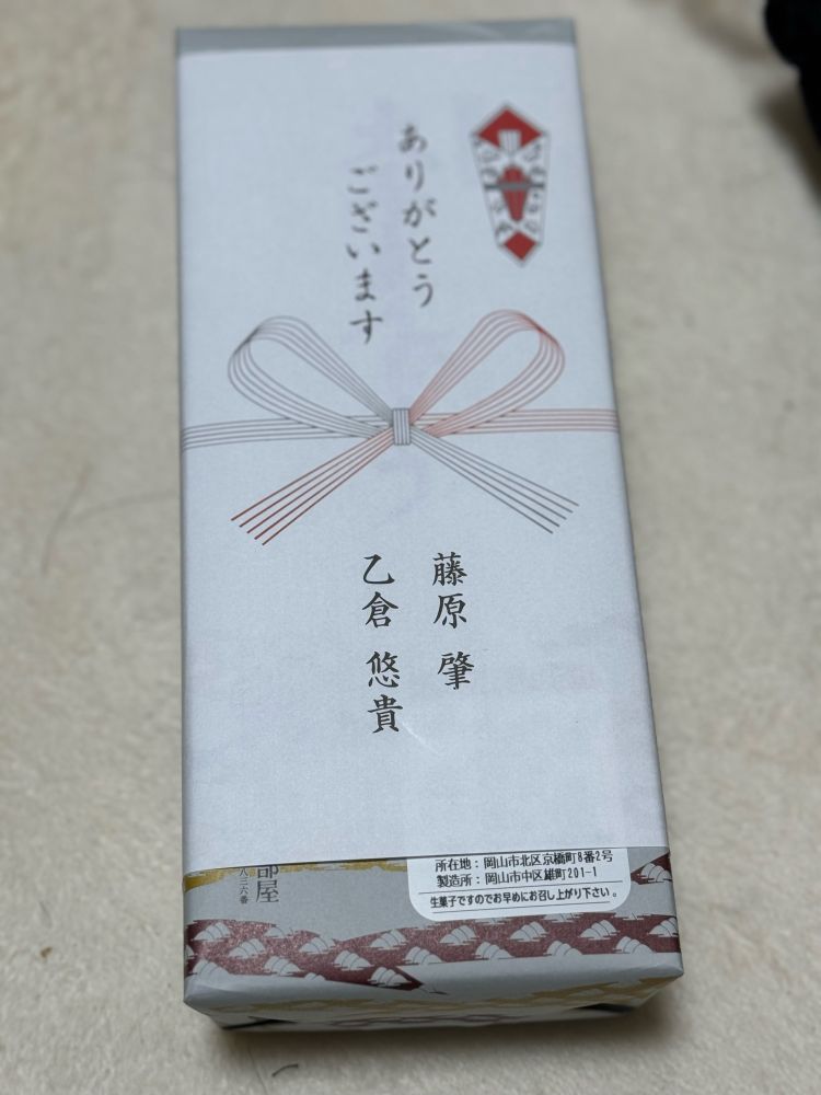引き出物のような藤原肇と乙倉悠貴の表記の熨斗に包まれている大手まんぢゅう