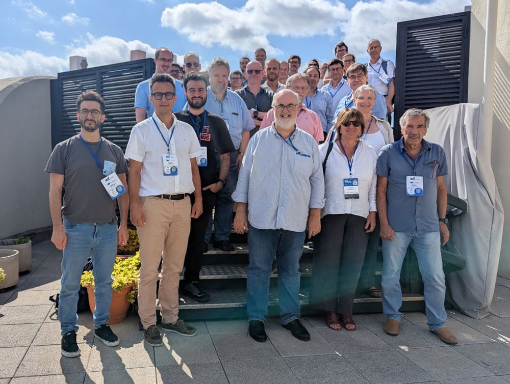 A large group of attendees standing together on an outdoor terrace under a sunny sky during the ET-PP Annual Meeting in Barcelona. Most participants are wearing blue lanyards and name badges, and the background shows modern rooftop structures.