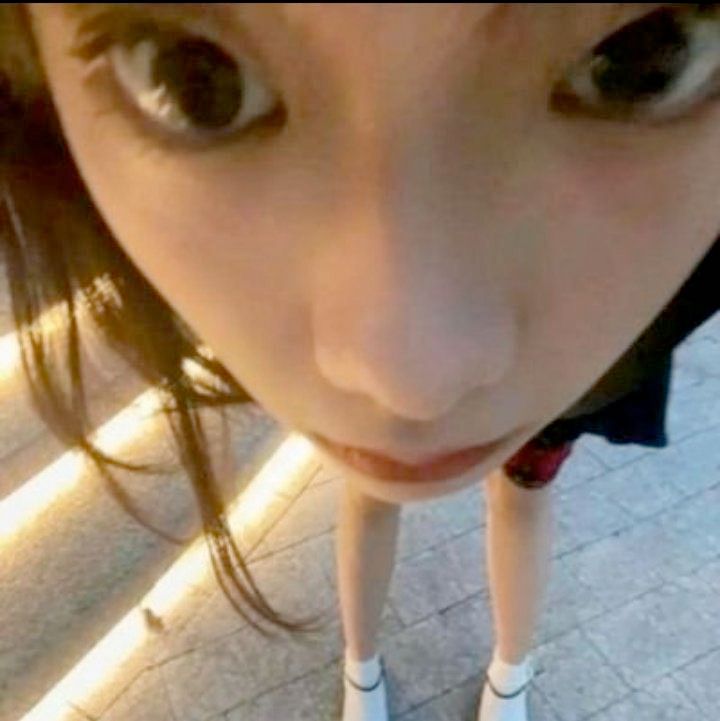 asian woman staring blankly at you face very close to camera like bug