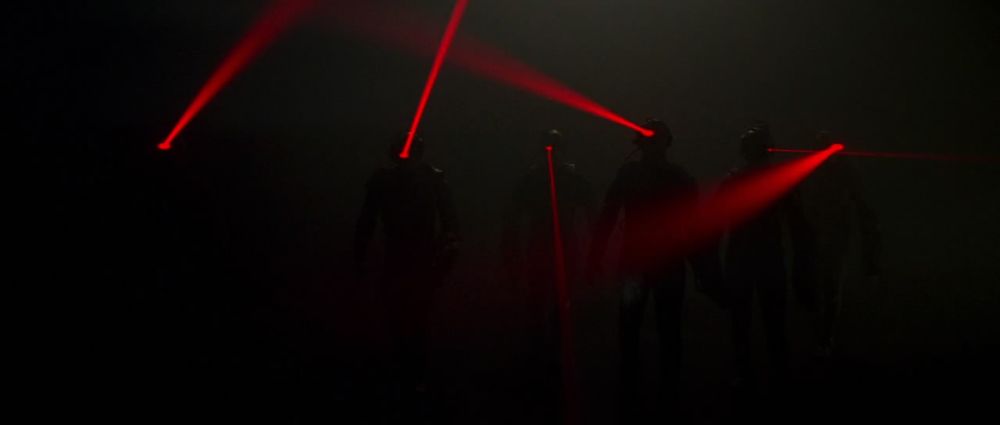 Still from FIRST CONTACT of the Borg, shrouded in darkness, appear only with their head-mounted laser pointers shining any light 
