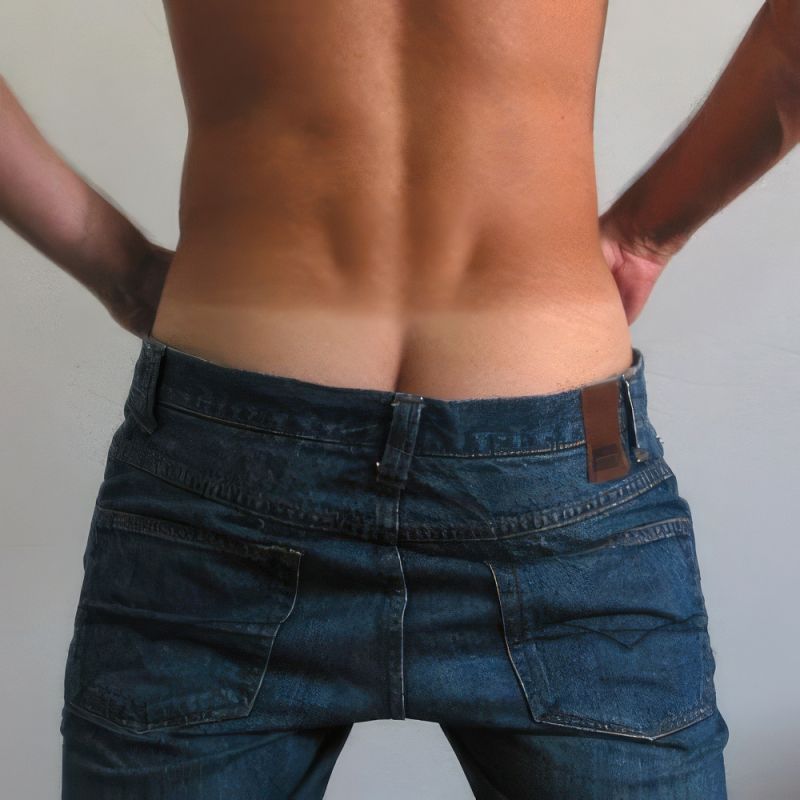 Photo of the author's toned, tanned backside where the figure's jeans are hanging low, showing "coin slot" cleavage. There is a well-defined tan line with the dark skin of the lower back contrasting with the light skin of the buttocks. The butt dimples are clearly defined in the dark skin right above the butt.