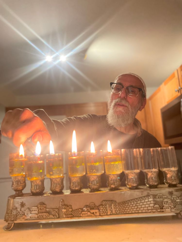 Man with white beard, lighting oil menorah for 5th night of Hanukkah! 