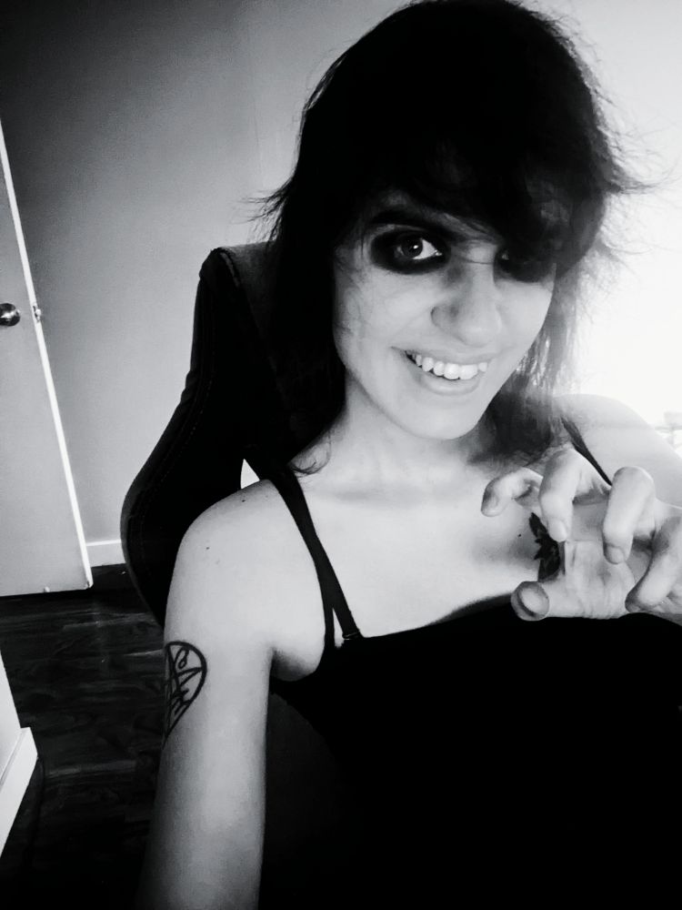 Selfie of AstridTheHorrorGirl doing a claw motion with her hand and gnashing her teeth