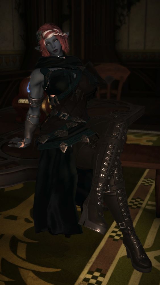 Tali, a duskwight elezen with blue-grey skin, white-streaked, shoulder-length pink hair, silver, slitted eyes, freckles, and pinkish-white scales on her neck, chest, and arms. She is wearing a choker with a crescent moon, and flowers in her hair, as well as a dark green and brown sleeveless tunic with silvery embellishments. She is sitting on a dining table with one leg crossed over the other, looking very unimpressed.