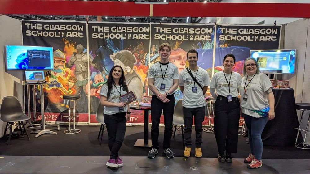 A group of five people in front of The Glasgow School of Art stand at the EGX career fair.