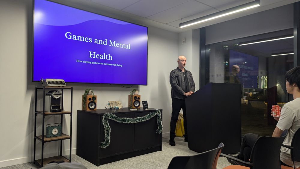 Roelof Neumann at the Glasgow Games Soapbox, standing next to display with text 'Games and Mental Health '