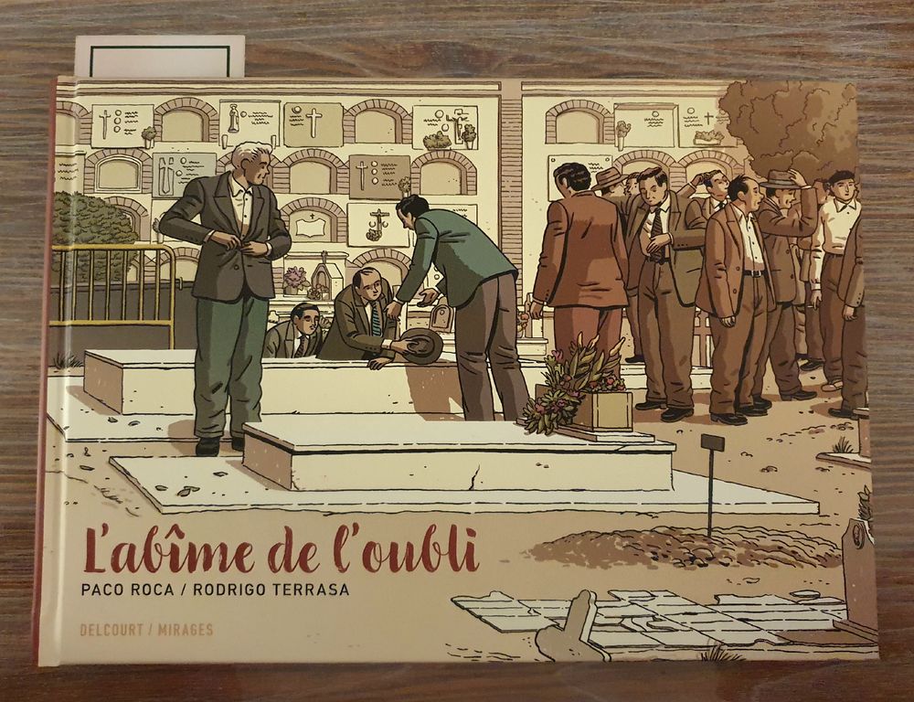 Couverture de la bande dessinée "L'abîme de l'oubli", des hommes en costume sortent d'une fosse commune du franquisme