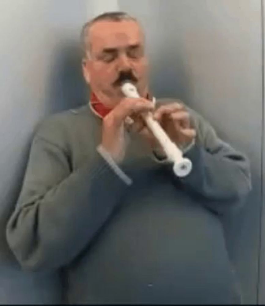 a man with a mustache is playing a recorder in a bathroom .