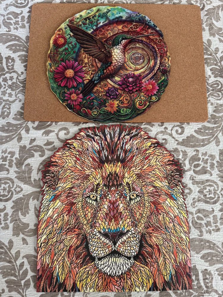 Two wood puzzles, a hummingbird and a lion