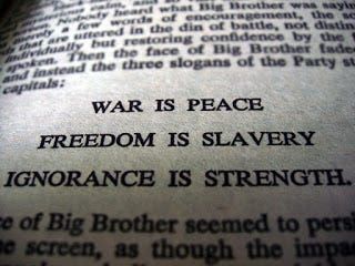 Book page from 1984 with the slogans “war is peace” “freedom is slavery” and “ignorance is strength”