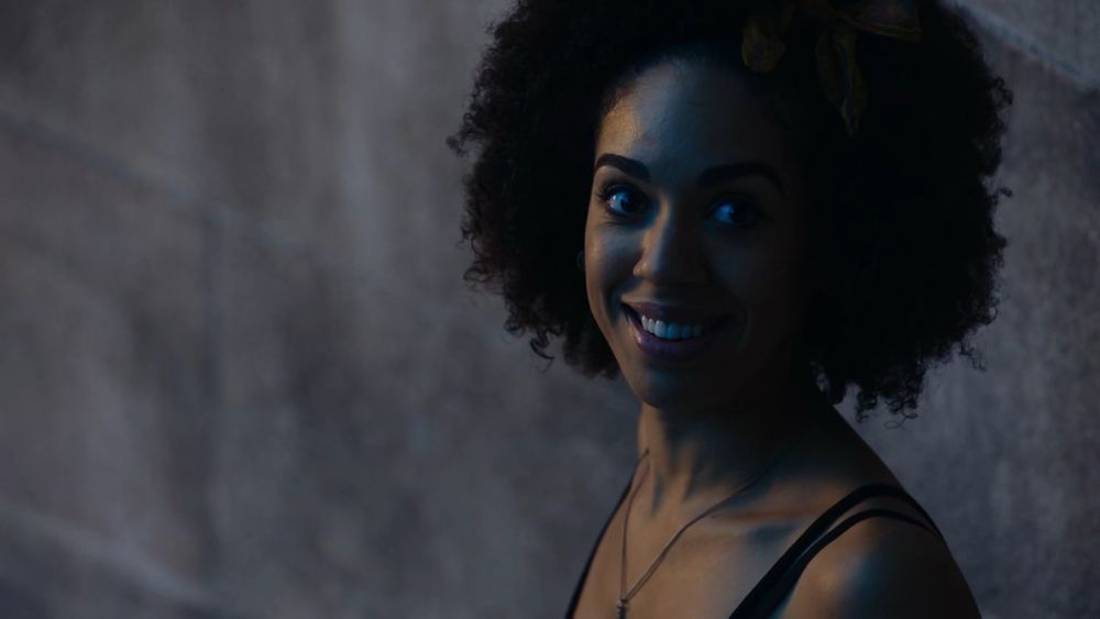 It's Bill Potts. She has stopped halfway down the stairs, on her way to join the Doctor in his adventures. She's smiling back at us, excited.