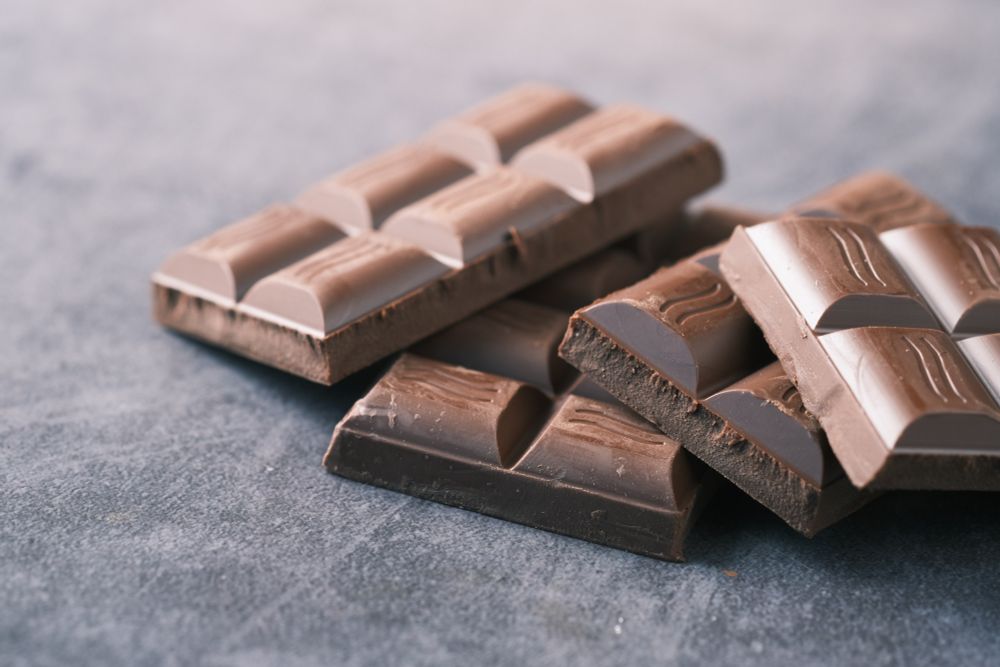 Photograph of four bars of chocolate piled on top of each other.