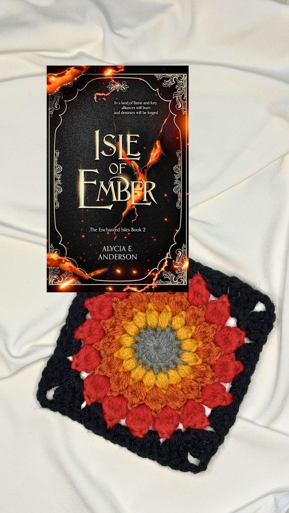 Isle of Ember by Alycia E. Anderson. Book cover is black with lava cracks. Next to it is a crocheted granny square in gray, yellow, orange, red, and black.