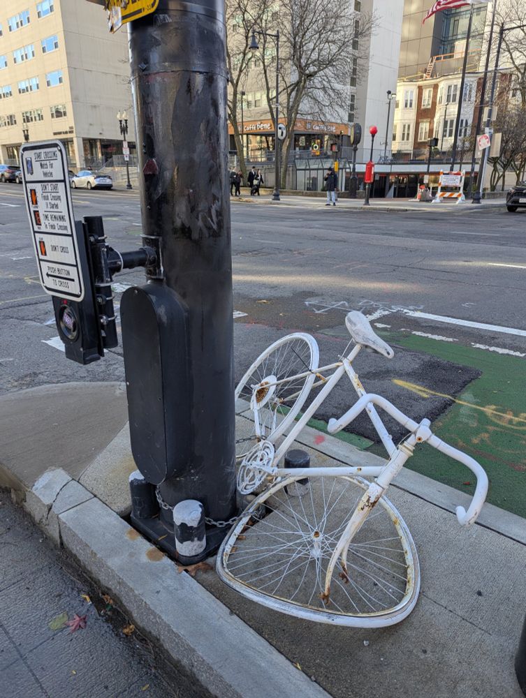 Ghost bike memorial placed at the intersection but the front wheel is mangled after being hit by a driver