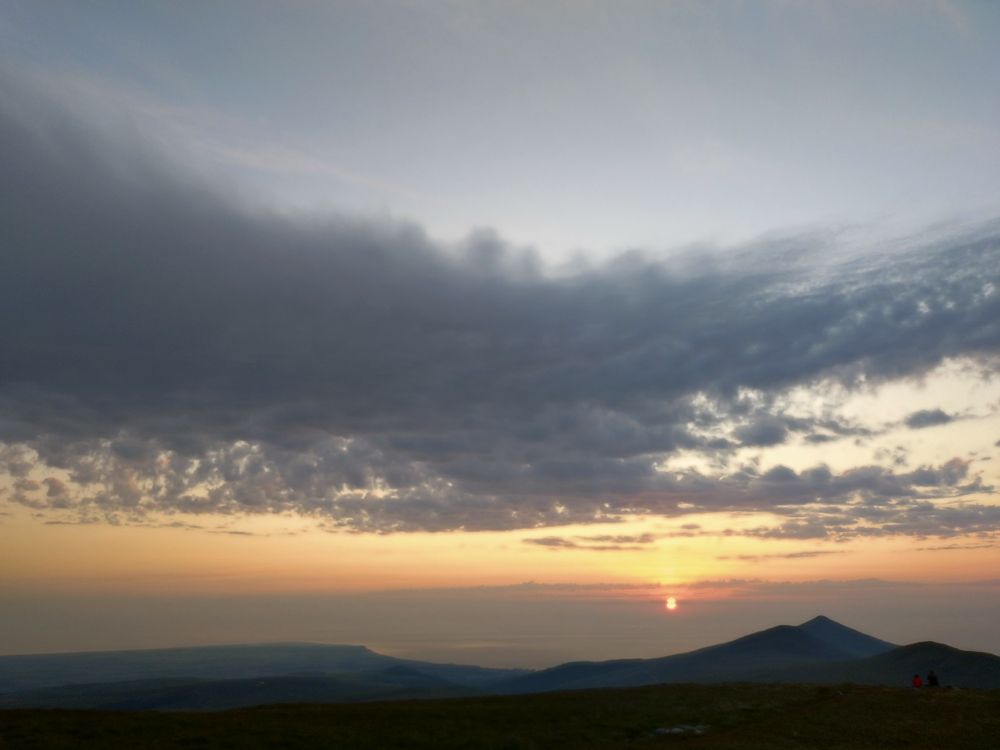 This is the view from our highest mountain, Snaefell. Please don't mock us for the size of our hills. Photo is looking northwest over the hazy hills and the sea to where the sun is just breaching the horizon.
