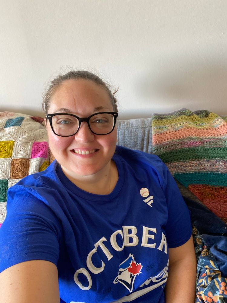 A woman smiling wearing a Blue Jays t-shirt