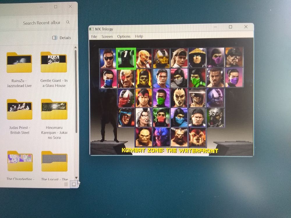 A computer desktop displaying mp3 albums and Mortal Kombat Trilogy