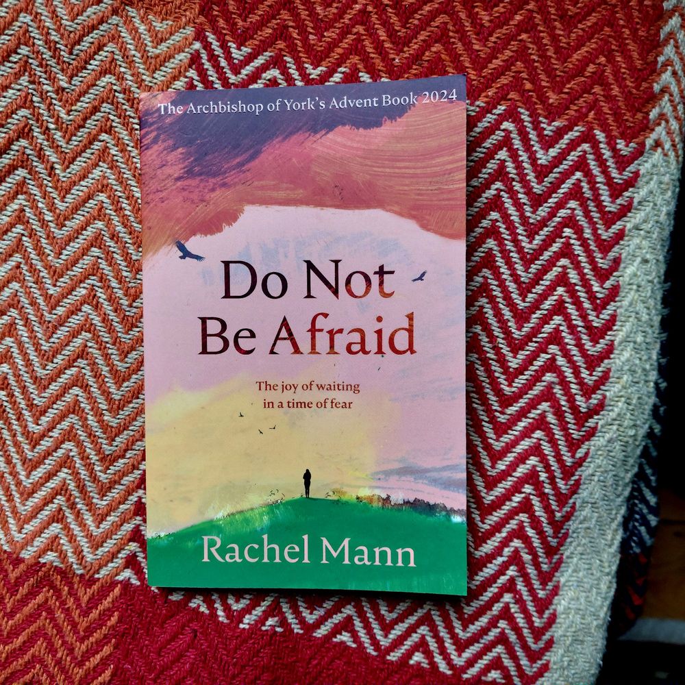 Rev Rachel Mann's Advent Book Do Not Be Afraid on a colourful blanket with orange zigzag patterns