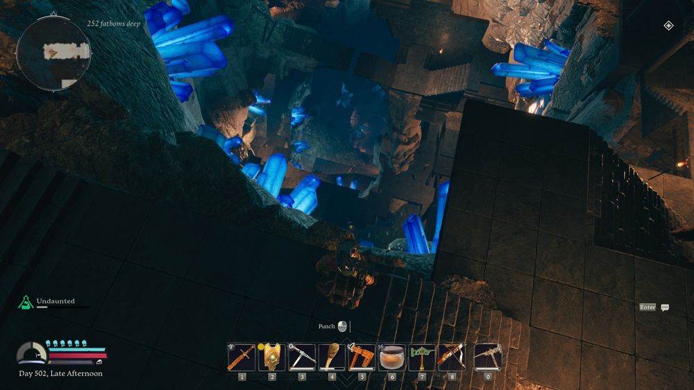 A helmeted Dwarf looks out over a vast mostly lit, deep cavern that is filled with glowing blue crystals and several levels of stairs, platforms, and bridges.