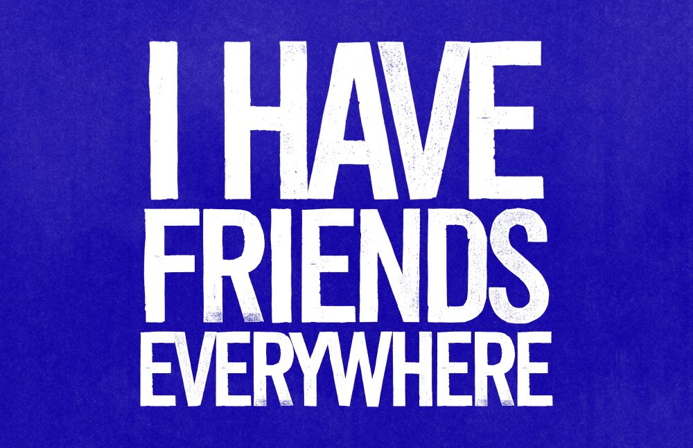 large blue sign that says, in tall white font: "I HAVE FRIENDS EVERYWHERE"