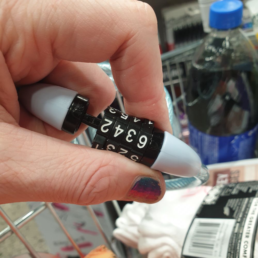 My hand is holding the Master combination lock attached to the trolley. The rod bit is partly out, showing it is unlocked. The combination is 6 3 4 2.

It's probably the store code or something.

I guess I'm a Master lockpicker now?