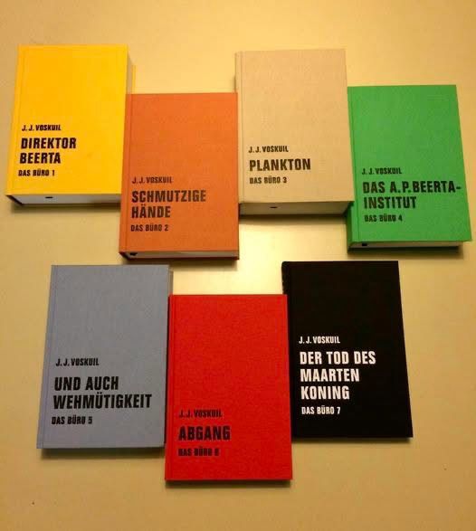 Alle sieben Bände des Romans liegend neben- und untereinander auf einem gelben Untergrund 