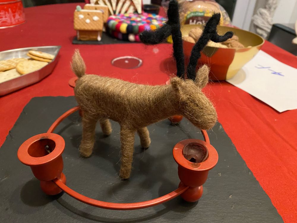 Picture of a needle felted reindeer, missing nose and eyes.