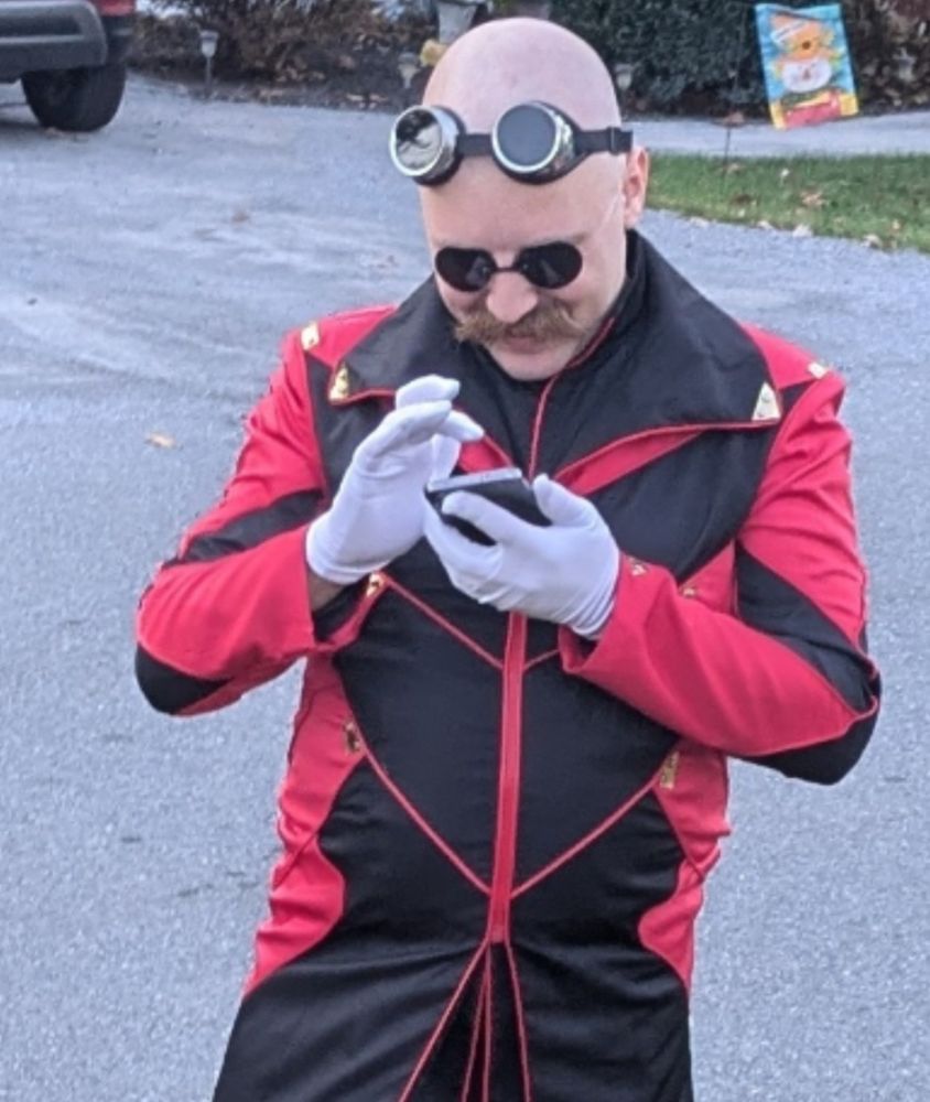 A jovial eggman tapping down at his phone with a grin