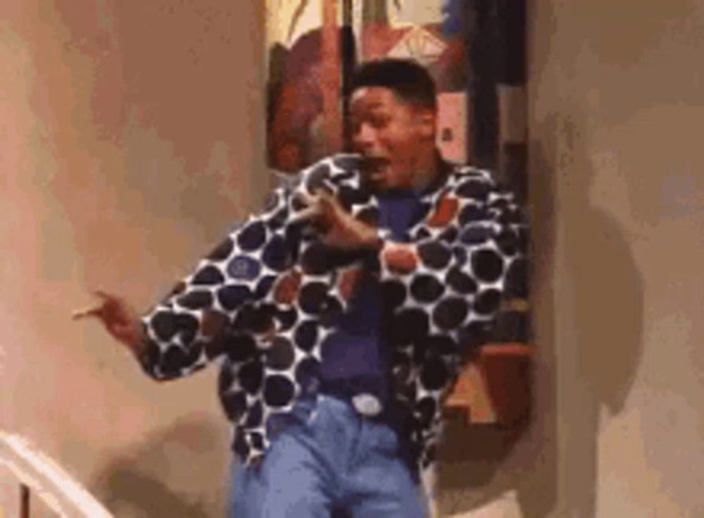 a man in a polka dot jacket and jeans is dancing on a set of stairs .