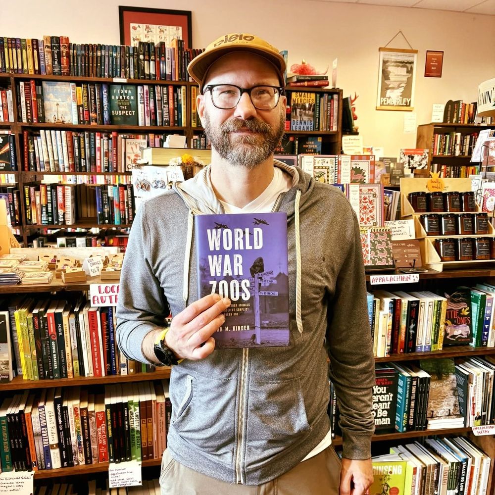 Photo of author holding book in bookstore