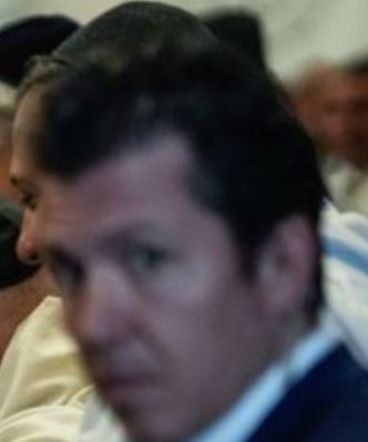 A blurred photo of a man looking into the camera asking you why you let Eric Adams wear that.