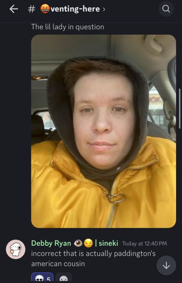 A discord thread from a channel called “venting here.” There is a selfie of myself facing the camera in a black hoodie and yellow puffer jacket. The text above says “the little lady in question.” Below, a friend replies, “incorrect that is actually paddington's american cousin”