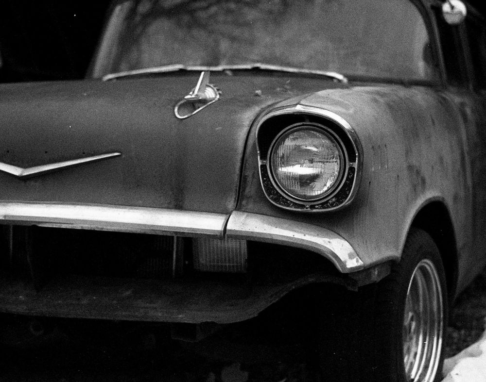 Antique car with chrome bumper and trim work shot on black and white film.