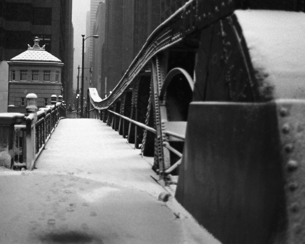 Black and white image of a bridge in downtown Chicago with a light dusting of snow.