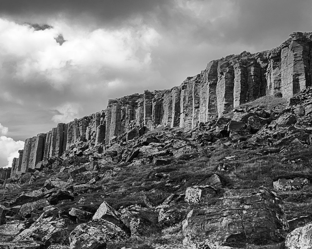 Striking black and white image of columnar basalt formations 50 feet tall forming a natural fortress.