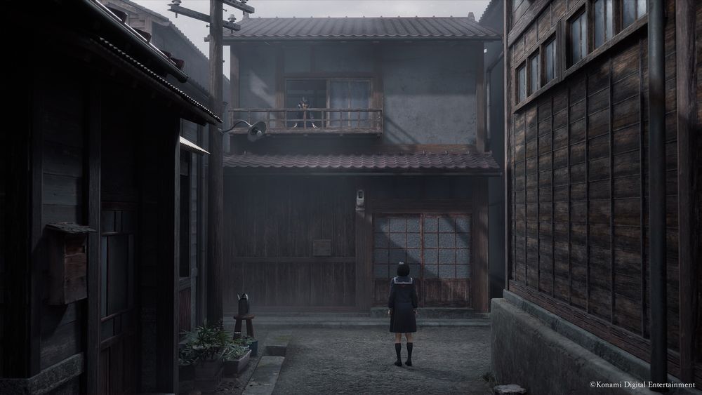 A screenshot of the game, showing a part of a neighbourhood in rural Japan. Almost at the center of the picture, there's the game's protagonist Hinako, seen from behind, looking up to a balcony. On the balcony, there's another girl wearing a school uniform.