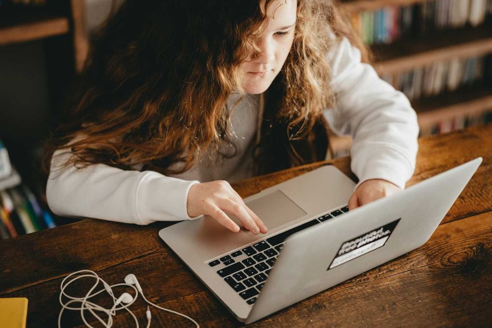 A photo representing a young girl using a computer