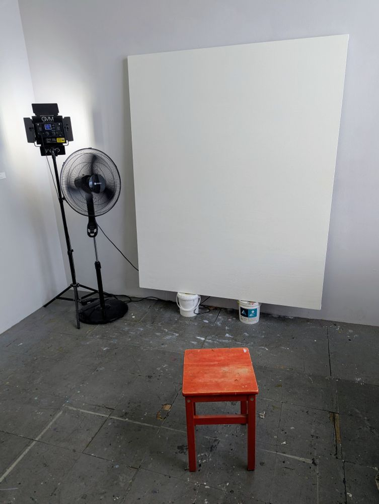 Large blank canvas in an artist's studio.