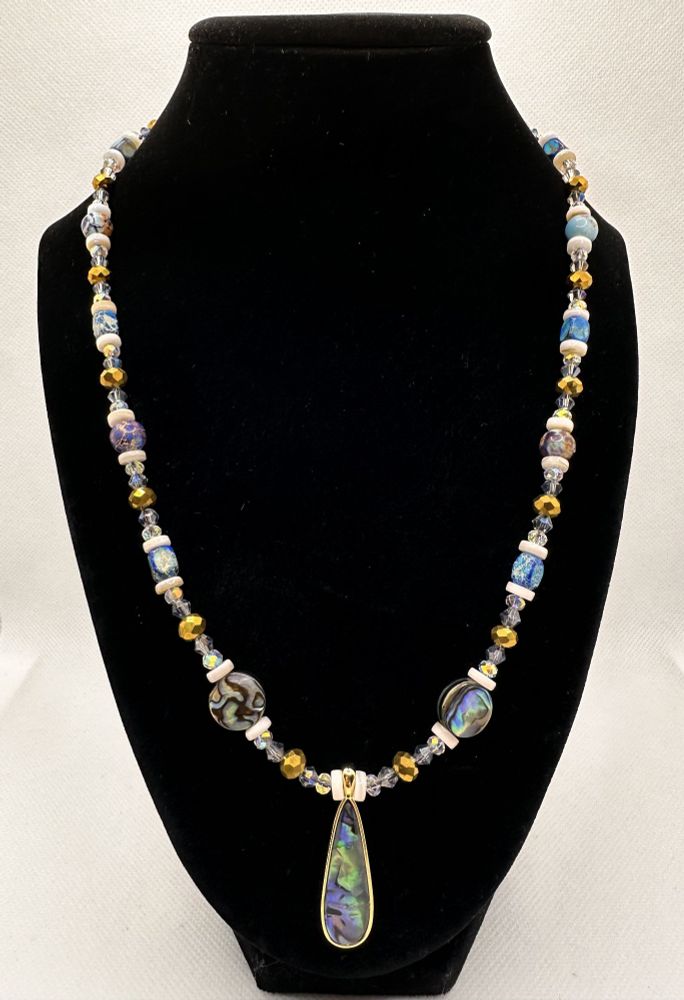 A gorgeous necklace with pearl spacers, multicolored cool-toned beads, fancy faceted spacers (inc bigger gold ones), two big abalone beads and a gorgeous abalone drop centerpiece. Roughly 21-22in length.