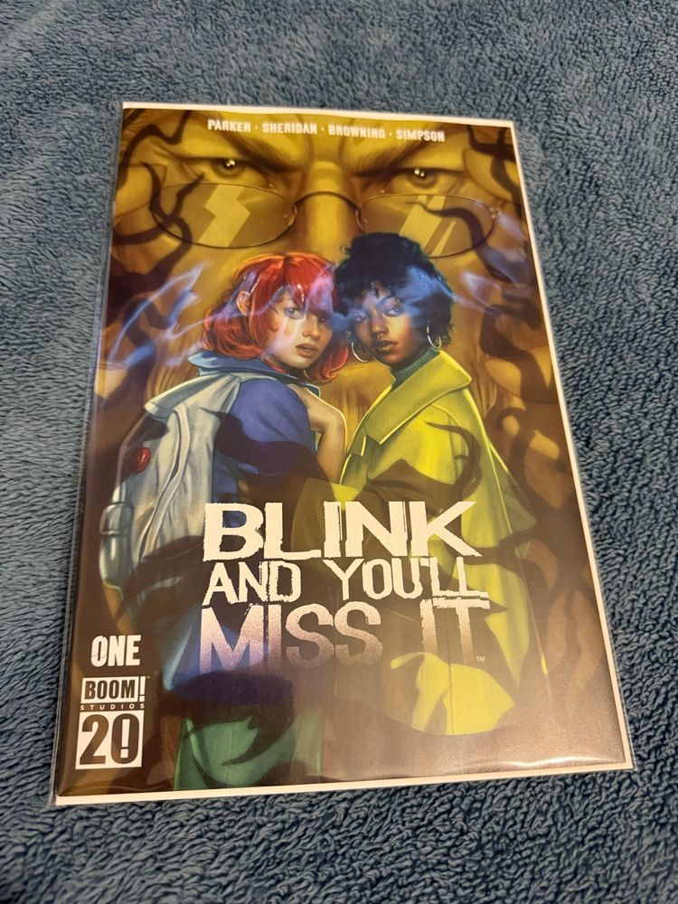 Blink and You’ll miss it #1 cover with the younger versions of the lead characters and a mysterious glasses wearing character looking on 