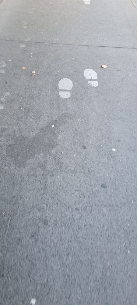 White foot markers on the floor indicating a place to stand and/or walk