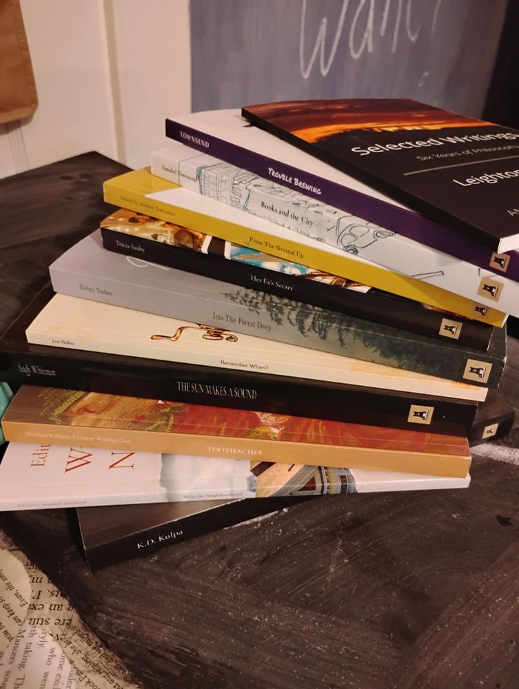 A stack of Pete's Press books fanned out on a chalkboard topped table