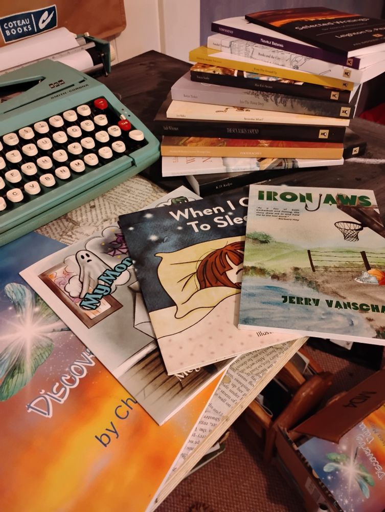 Four children's books published by Pete's Press, with a 1960s robin-egg blue typewriter in the top left of the frame
