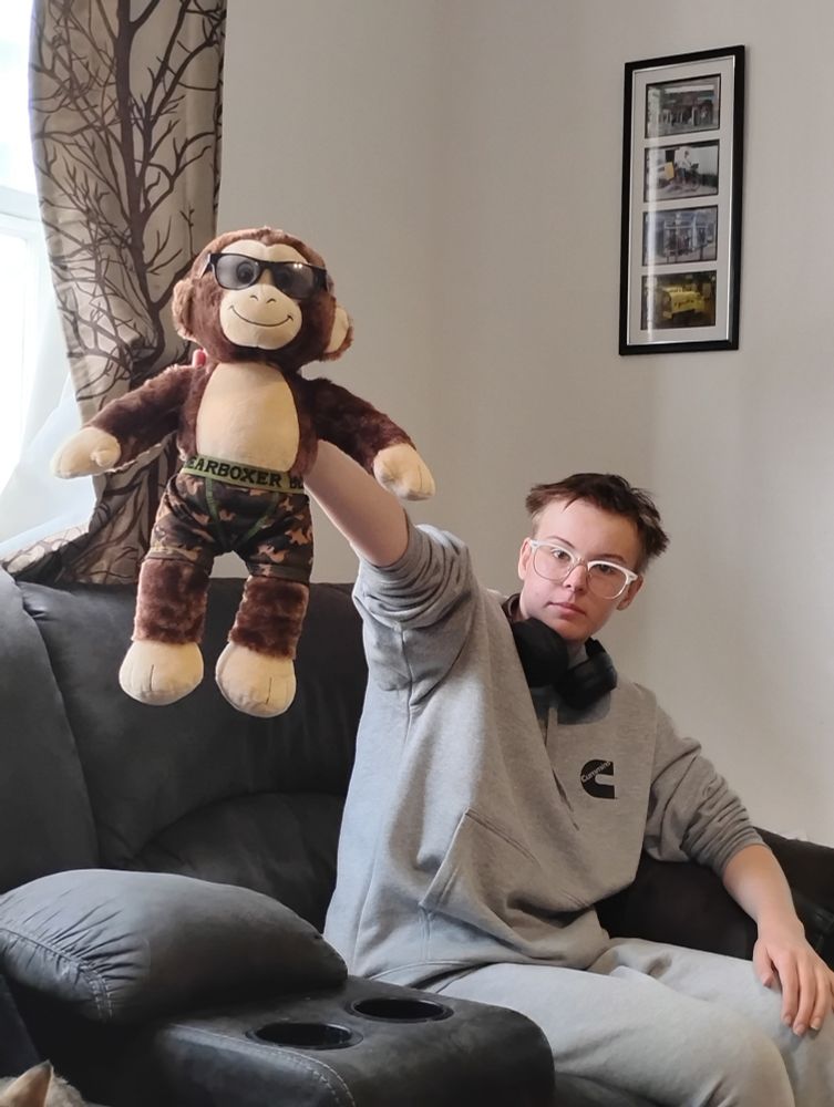 My eldest kiddo and Timmy Toughknuckles the stuffed monkey. Timmy is wearing mini sunglasses and camo pattern boxer shorts. 