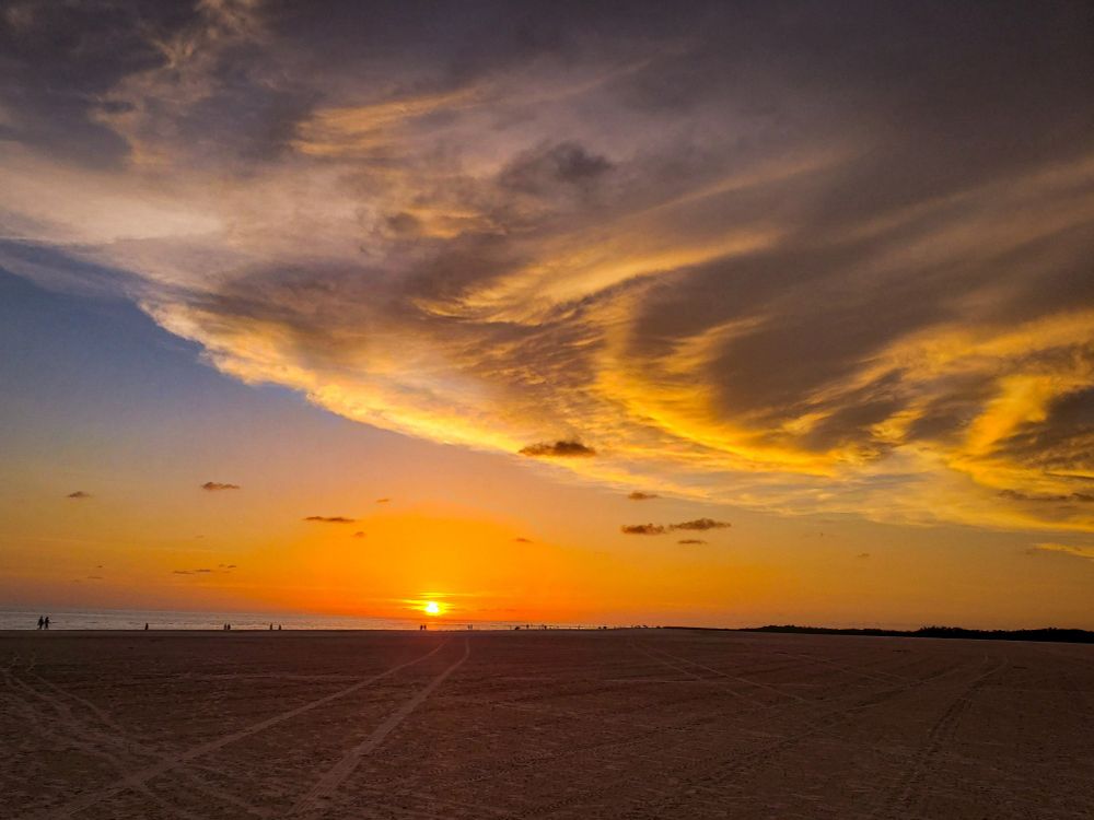 A sunset over the gulf of Mexico as a white saucer cloud approaches.  