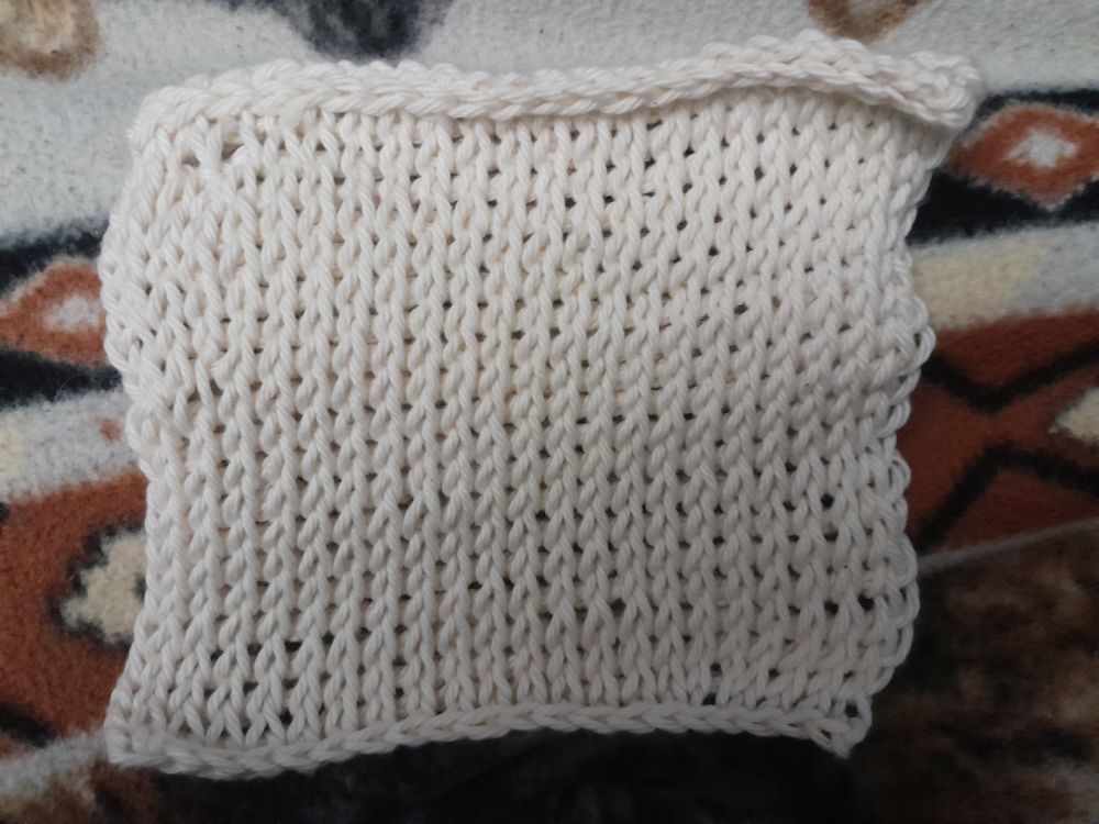 Front side of a Tunisian crochet square of a soft off white bamboo yarn. This variation looks knitted.