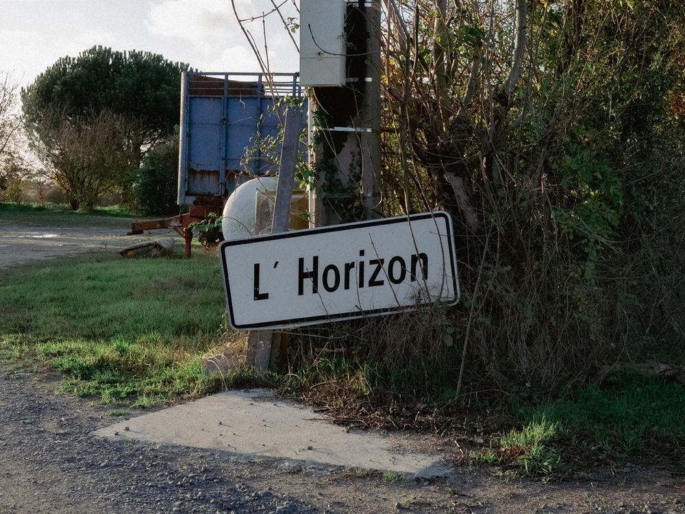 Panneau indiquant L'Horizon à l'entrée d'une cour de ferme.